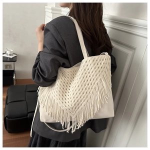 Dettaglio della borsa tote all'uncinetto crema con frange lunghe e motivo intrecciato