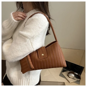 Detail of caramel brown woven hobo bag showing texture and matching mini zipper pouch
