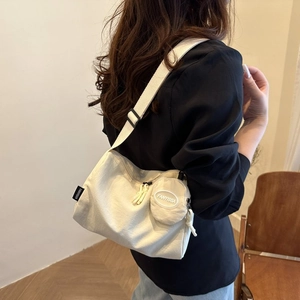 Détail du sac cabas en nylon blanc cassé avec bandoulière et petit porte-monnaie rond
