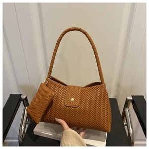 Detail of brown woven hobo bag with matching coin purse on minimalist background