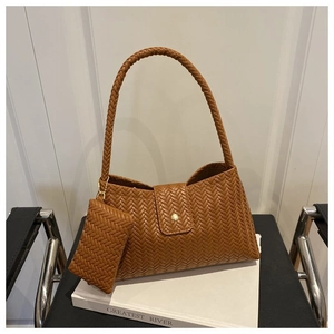 Close-up of caramel brown woven leather texture on a shoulder bag with mini pouch