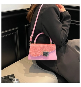 Detail of pink croc-embossed handbag with modern black and gold square metal buckle