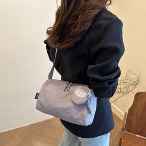 Détail du sac bandoulière en nylon gris clair avec petit porte-monnaie et logo