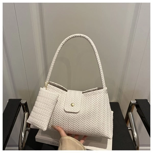 Detail of woven white shoulder bag with detachable mini purse and gold metal buckle