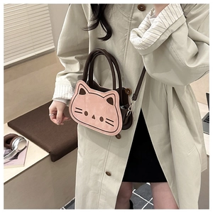 Close-up of cute pink cat face crossbody bag with brown leather handles and strap