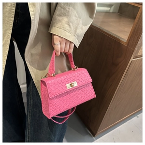 Détail du sac à main rose à texture tissée avec élégant fermoir rotatif doré en métal