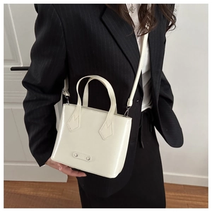 Off-white minimalist crossbody bag with shiny leather texture and silver hardware