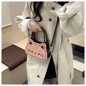 Close-up of pink cat-shaped shoulder bag with embroidery and premium metal buckles