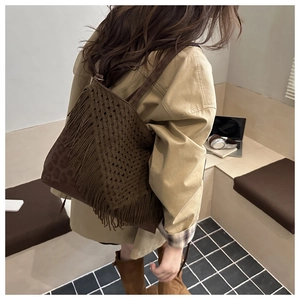 Dettaglio della borsa boho marrone con trama all'uncinetto, nappe e accenti leopardati