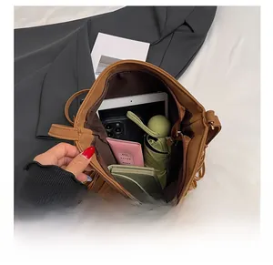 Vue de dessus du sac seau en cuir marron montrant sa grande capacité et ses accessoires