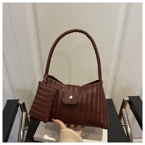 Detail of dark brown woven underarm bag with matching coin purse and gold metal buckle