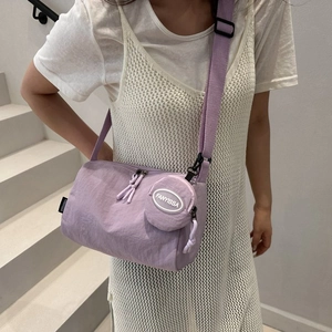 Détail du sac bandoulière en nylon violet avec porte-monnaie assorti sur modèle