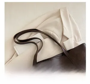 Detail showing the reinforced stitching and durable shoulder strap on a brown tote bag