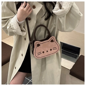 Detail of pink cat-shaped kids crossbody bag with brown leather strap and embroidery