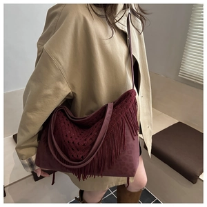 Dettaglio borsa shopper bordeaux con trama leopardata e lunghe frange stile boho