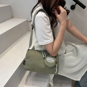 Détail du cabas en nylon vert mousse avec tirette de zip nouée et petite pochette ronde