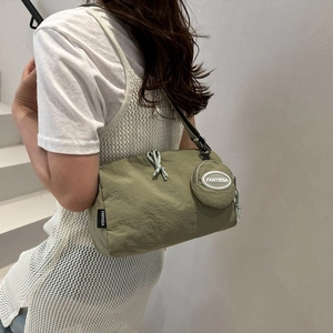 Détail d'un sac cabas en nylon vert olive avec pochette ronde et étiquette de marque
