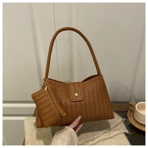 Detailed view of brown woven shoulder bag with matching mini zip pouch and gold hardware