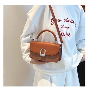 Sac à bandoulière bicolore avec boucle argentée porté par un modèle en style décontracté