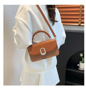 Détail du sac à main bicolore avec texture tressée et boucle argentée chic et moderne