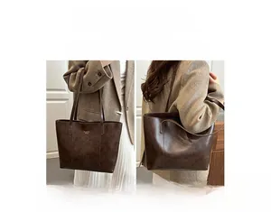 Detail showing versatile carrying options for the deep brown tote bag with logo