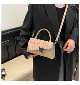 Detail of beige faux crocodile leather flap and metallic square buckle on crossbody bag