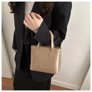 Detailed shot of khaki glossy leather bucket bag with silver Fashion metal plate