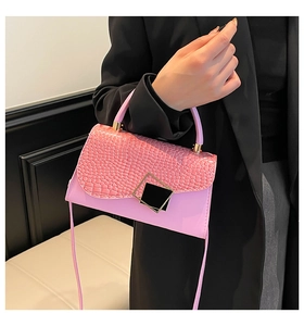 Detailed close-up of pink faux crocodile leather flap and black gold metallic clasp buckle