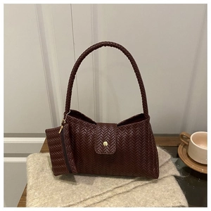 Detailed texture of woven burgundy leather shoulder bag with matching mini coin purse