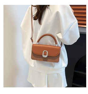 Détail du sac bandoulière tissé bicolore avec rabat en cuir et boucle ovale en métal argenté