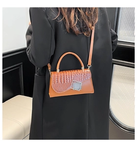 Brown crocodile texture handbag with silver geometric lock shown on a female model