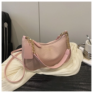 Gros plan du sac bandoulière rose tissé avec poignée en chaîne dorée et cuir souple