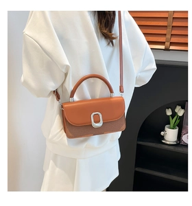 Détail du sac bandoulière marron caramel montrant le contraste des textures et la boucle