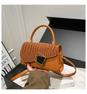 Detail of a brown croc-embossed flap handbag with an elegant metallic square buckle