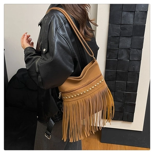 Detailed close-up of brown vintage hobo bucket bag featuring long fringe and gold studs