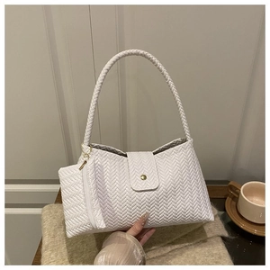 Detail of white woven texture shoulder bag with round metallic clasp and mini pouch