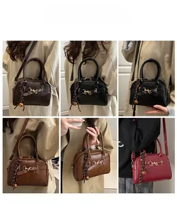 Detail showing classic boston style handbag with metallic horsebit and bell charm