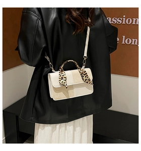 Detail of off-white leather handbag with leopard print scarf handle and gold hardware