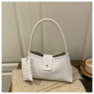 Detail of white woven underarm bag with herringbone texture and mini zip pendant