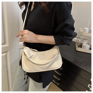 Détail du sac bandoulière tressé crème avec chaîne dorée et texte Fashion & Bags chic