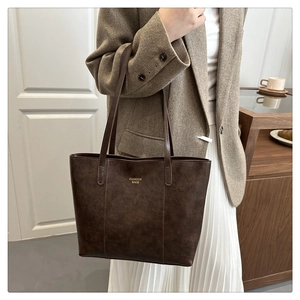 Sac fourre-tout marron foncé avec texture vintage porté par un mannequin en scène de vie