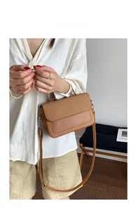 Close-up of a brown vintage shoulder bag featuring a woven textured flap and leather strap