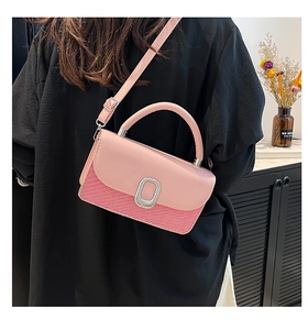 Détail du sac bandoulière rose avec texture tissée, boucle argentée et lanière cuir