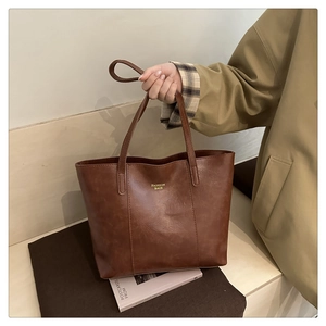 Détail du sac cabas marron vintage avec lettrage doré et texture en similicuir
