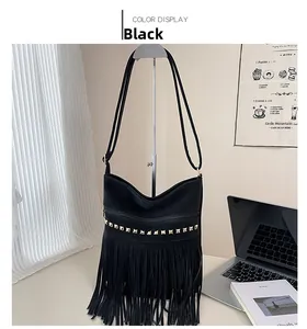 Detail of black bohemian bucket bag with gold pyramid studs and long fringe tassels