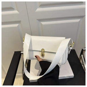Macro detail of white PU leather shoulder bag with a gold metal cylinder rotary lock
