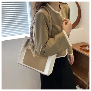 Detail of white woven tote bag with silk scarf handle and FASHION BAG leather pocket