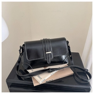 Dettaglio borsa baguette in pelle cerata con cuciture a contrasto e fibbia dorata