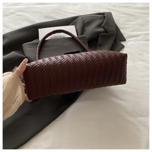 Detailed close-up showing the intricate V-shape woven texture of the red-brown hobo bag