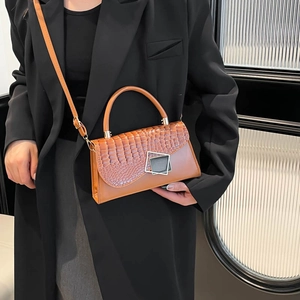 Brown crocodile pattern crossbody bag with metal buckle and shoulder strap in 45-degree view